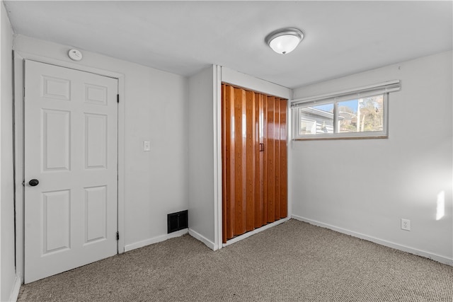 unfurnished bedroom featuring light carpet and a closet