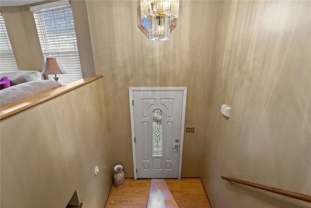 entryway with light hardwood / wood-style flooring and a chandelier