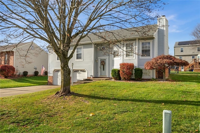 bi-level home featuring a garage and a front lawn