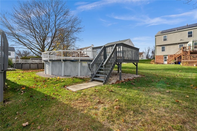 rear view of house with a swimming pool side deck and a lawn