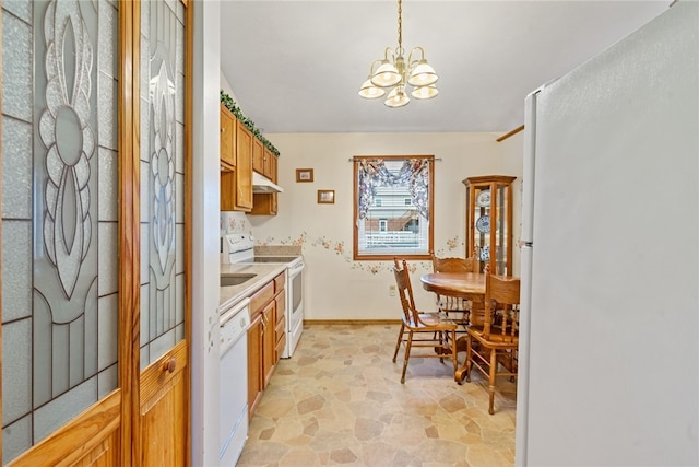 kitchen featuring a notable chandelier, white appliances, and hanging light fixtures