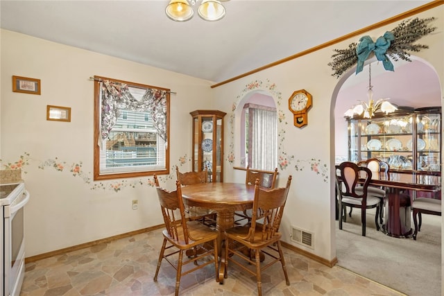 carpeted dining room featuring an inviting chandelier