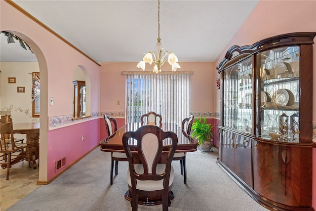 dining room featuring light colored carpet, lofted ceiling, and a notable chandelier