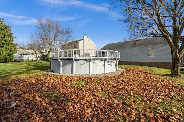 rear view of house with a yard and a pool side deck