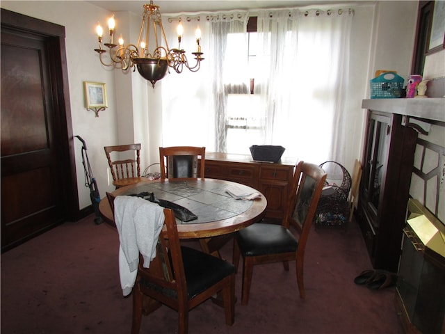 dining space with an inviting chandelier and dark carpet