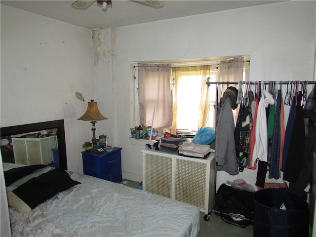 bedroom featuring radiator heating unit, ceiling fan, and carpet floors