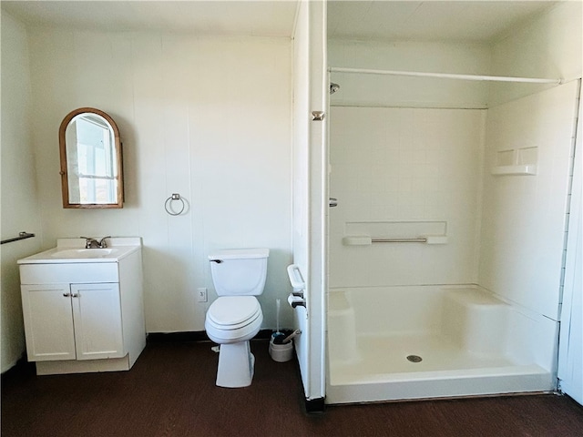 bathroom with a shower, vanity, wood-type flooring, and toilet