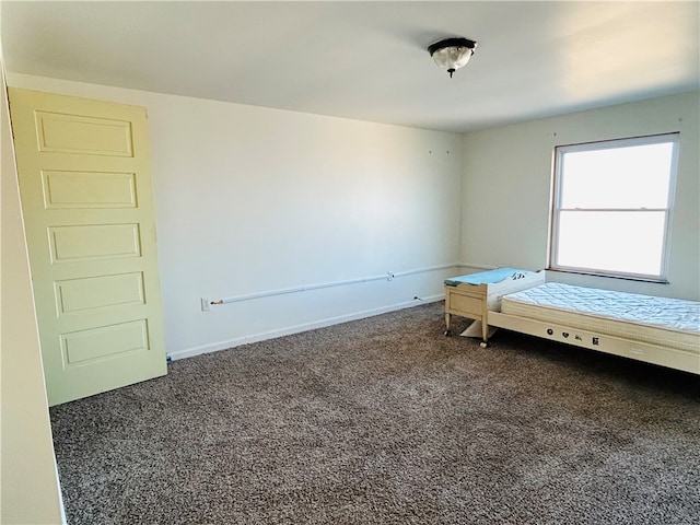 unfurnished bedroom with dark carpet