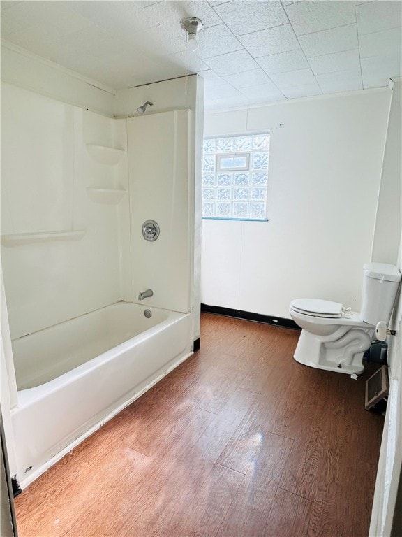 bathroom with bathtub / shower combination, wood-type flooring, and toilet