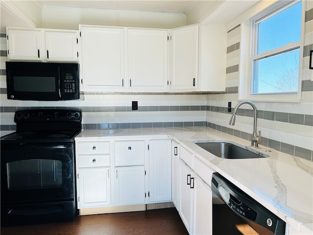 kitchen featuring tasteful backsplash, sink, white cabinets, and black appliances