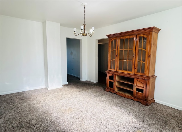 empty room with carpet and a chandelier