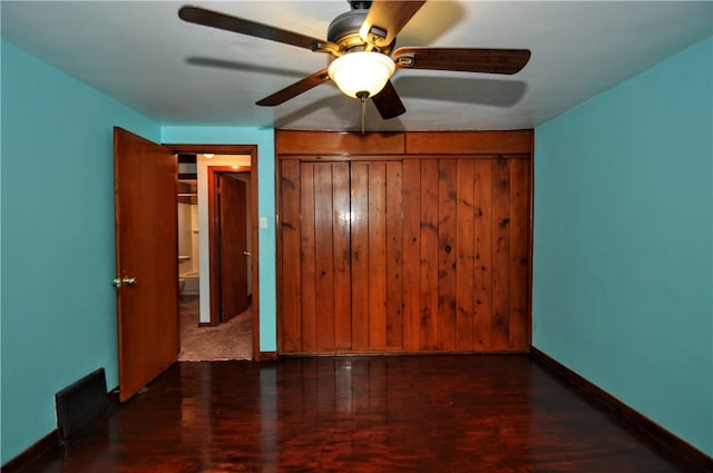 unfurnished bedroom featuring ceiling fan, dark hardwood / wood-style floors, and a closet