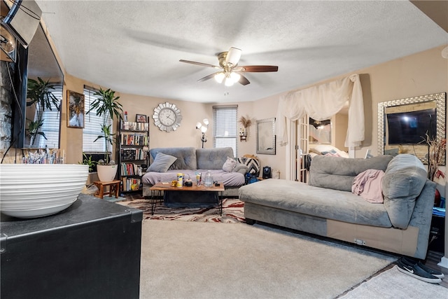 living room featuring ceiling fan, plenty of natural light, a textured ceiling, and carpet