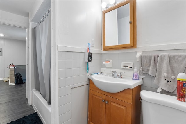 full bathroom featuring toilet, vanity, tile walls, and wood-type flooring