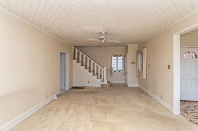 unfurnished living room with ceiling fan, carpet, and ornamental molding