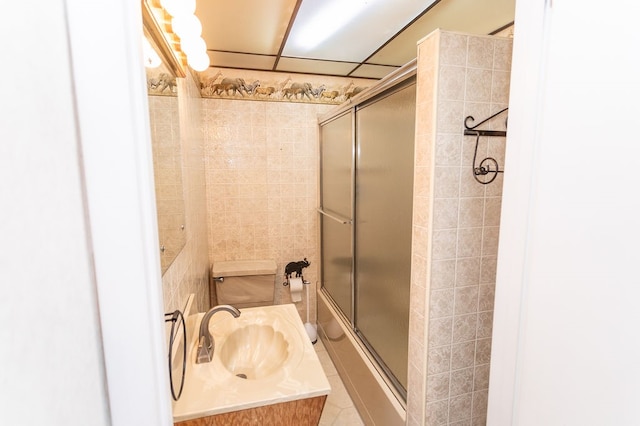 full bathroom with shower / bath combination with glass door, sink, and toilet