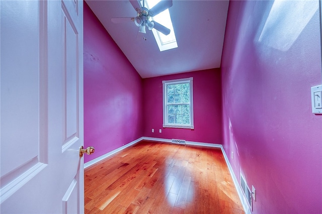 additional living space featuring lofted ceiling with skylight, ceiling fan, and light hardwood / wood-style floors