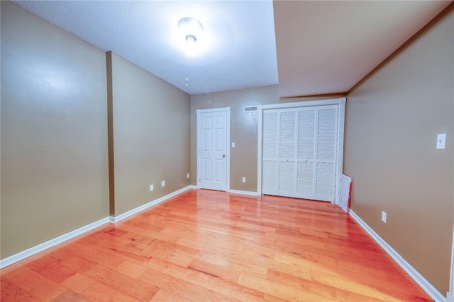 unfurnished bedroom featuring light hardwood / wood-style flooring and multiple closets