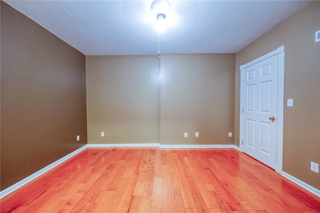 spare room with a textured ceiling and hardwood / wood-style flooring