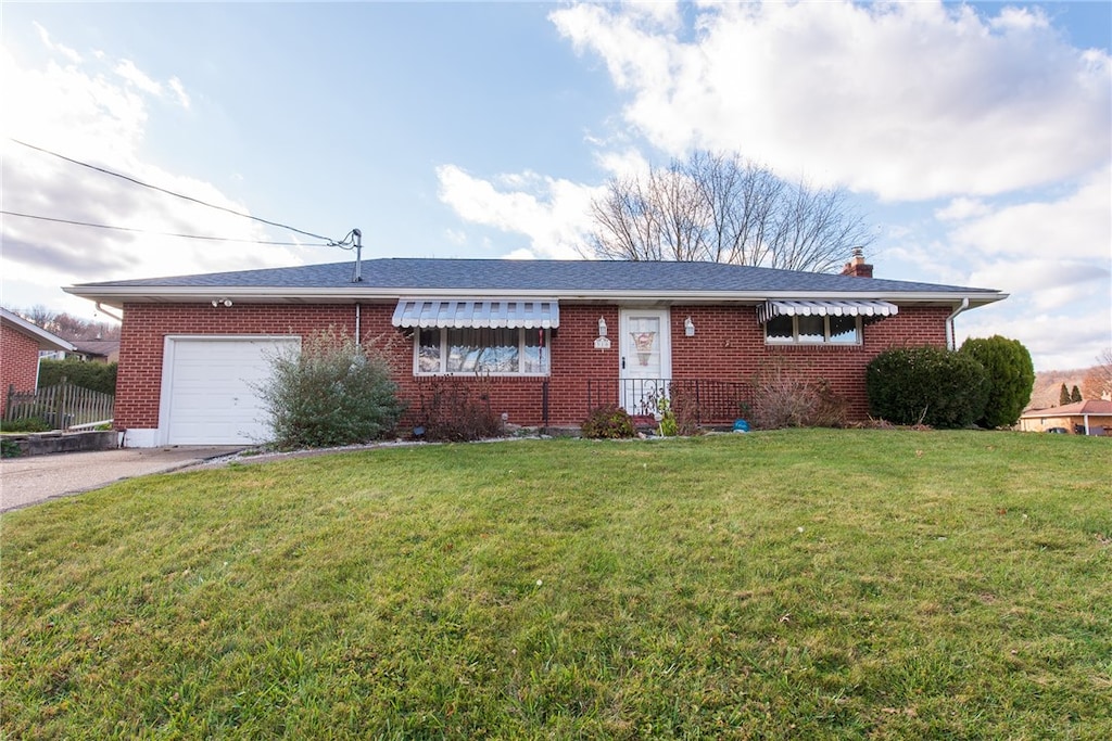 single story home with a garage and a front lawn