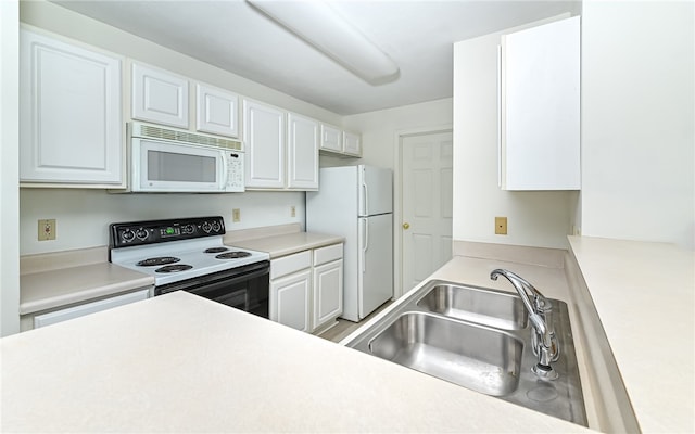 kitchen featuring white cabinetry, sink, and white appliances