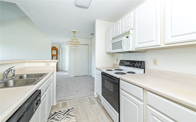 kitchen featuring white cabinets, sink, white appliances, decorative light fixtures, and light wood-type flooring