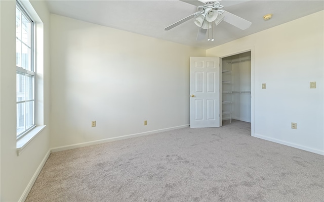 unfurnished bedroom with ceiling fan, a closet, and light carpet