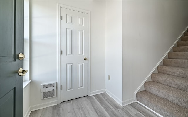 entrance foyer with heating unit and light wood-type flooring