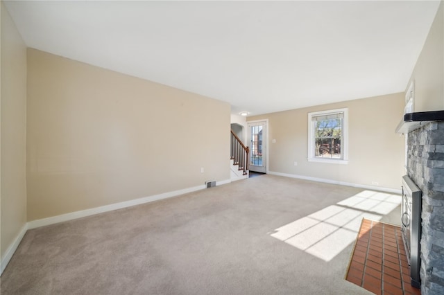 unfurnished living room featuring light carpet and a fireplace