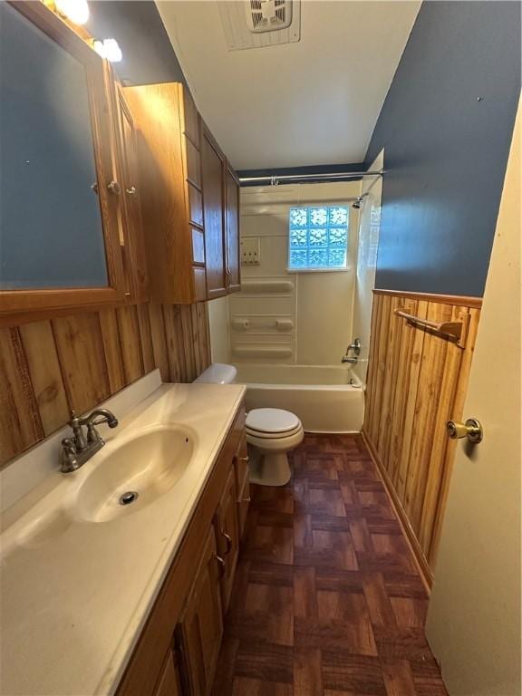 full bathroom featuring vanity, wooden walls, toilet, and lofted ceiling