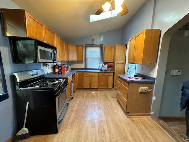 kitchen with stainless steel appliances, ceiling fan, lofted ceiling, and light hardwood / wood-style floors