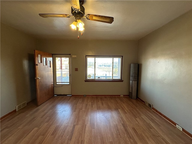 unfurnished room featuring hardwood / wood-style flooring, ceiling fan, and a wealth of natural light