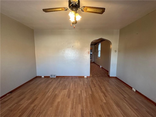1447 Fleming Ave, Mckees Rocks, PA 15136 - unfurnished room featuring arched walkways, a ceiling fan, baseboards, and wood finished floors