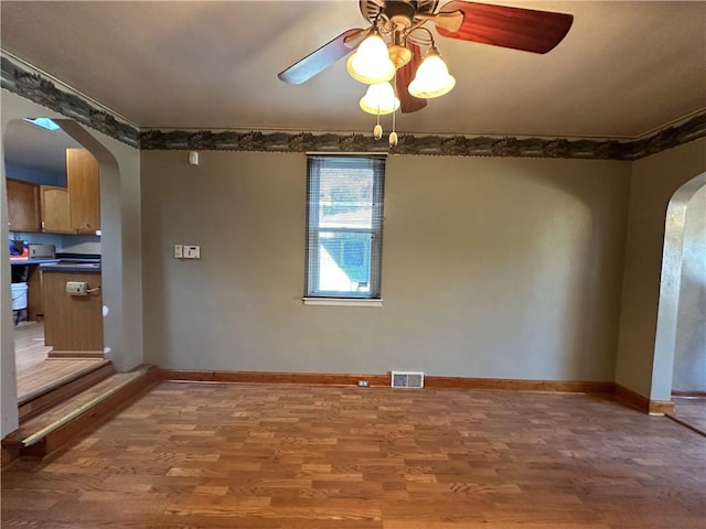 1447 Fleming Ave, Mckees Rocks, PA 15136 - unfurnished room featuring arched walkways, wood finished floors, ceiling fan, and baseboards