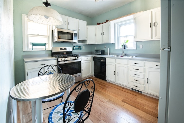 kitchen featuring white cabinets, sink, light hardwood / wood-style flooring, and stainless steel appliances