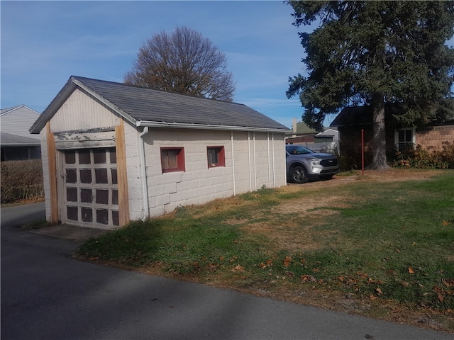 view of home's exterior featuring an outbuilding and a lawn