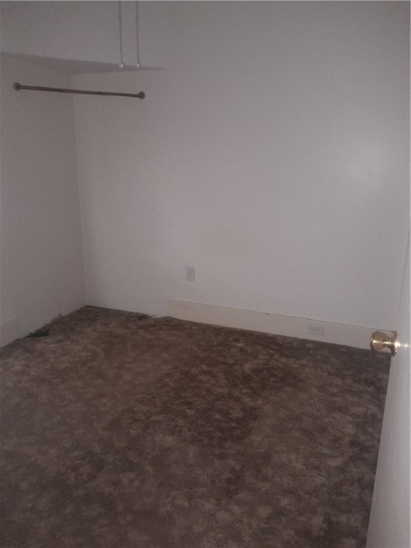 spare room with dark colored carpet