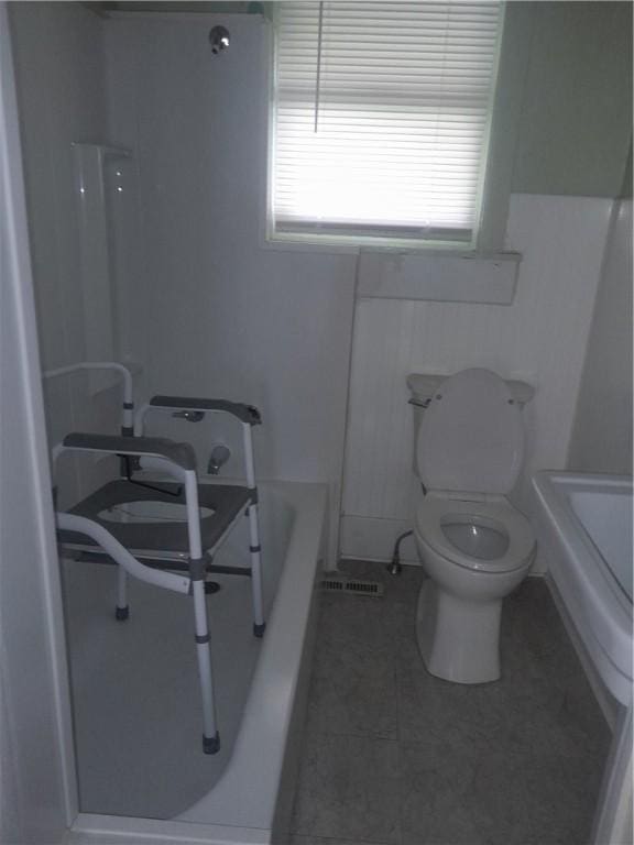 bathroom featuring toilet, tile patterned floors, a bathtub, and a shower