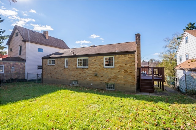 rear view of house with a wooden deck and a yard