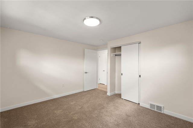 unfurnished bedroom featuring carpet flooring and a closet