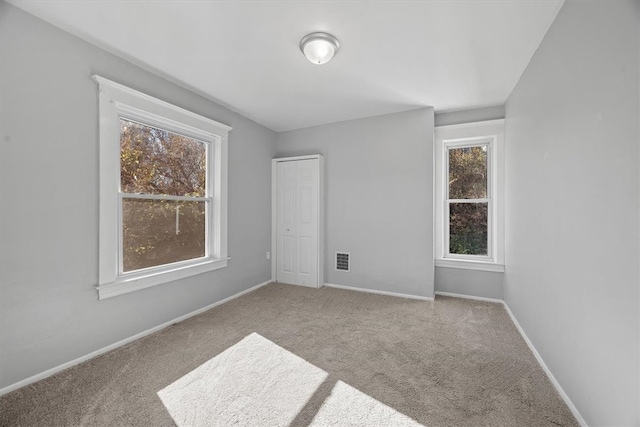 carpeted spare room featuring a healthy amount of sunlight