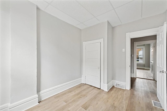 unfurnished room featuring a drop ceiling and light hardwood / wood-style floors