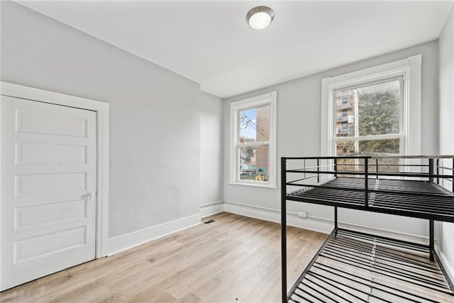 bedroom featuring light hardwood / wood-style floors and multiple windows