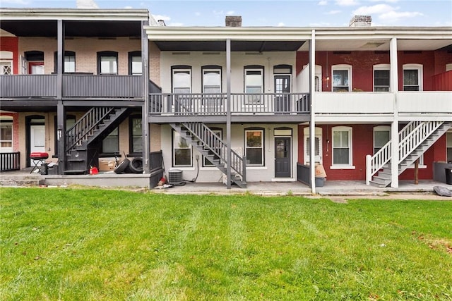 back of property featuring central AC and a lawn