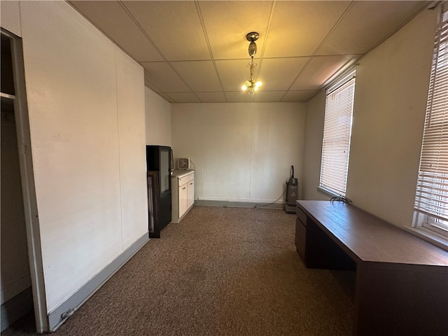 unfurnished office featuring carpet and a paneled ceiling