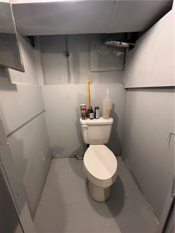 bathroom featuring concrete floors and toilet