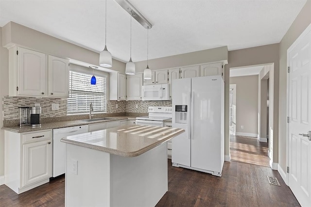 kitchen with white appliances, a kitchen island, sink, dark hardwood / wood-style floors, and white cabinetry