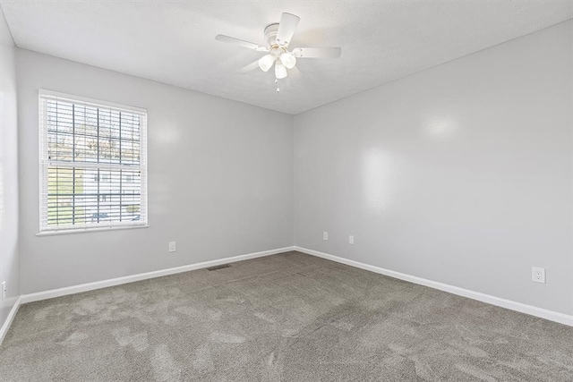 carpeted spare room with ceiling fan