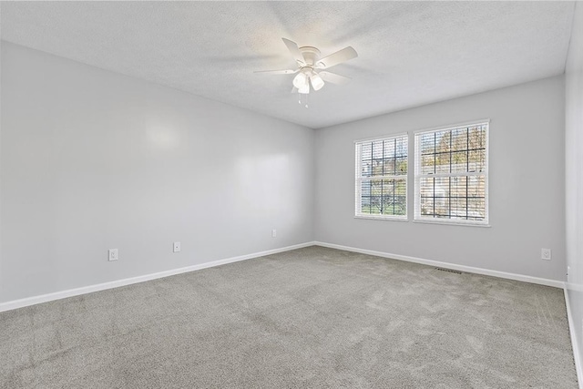 carpeted empty room featuring ceiling fan and a textured ceiling