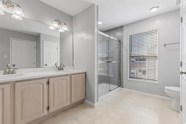 bathroom featuring vanity, toilet, and a shower with shower door